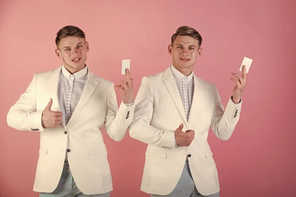 Men showing thumbs up with blank cards on pink background