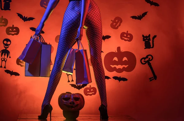 Feiertag-Halloween mit lustigen Karnevalskostümen auf einem Halloween-Hintergrund. Halloween-Dekoration und Gruselkonzept. Zauberkürbis. Glücklich lächelnde Frau auf Halloween-Hintergrund. — Stockfoto