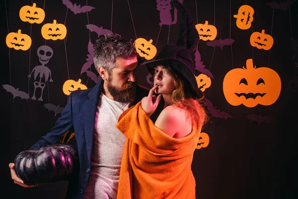 Holiday halloween with funny carnival costumes on a halloween background. Romantic couple. Horror faces. Halloween pumpkin head jack lantern with burning candles. Erotic moments.