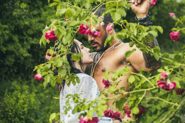 Sexy pareja besándose en el floreciente jardín. Mujer desnuda y hombre joven. Amantes jóvenes. Pareja sensual durante momentos calientes y sexy. Retrato de niña y niño en el interior . — Foto de Stock