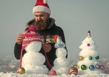 Kar xmas ağacı ve heykeller üzerinde mavi gökyüzü
