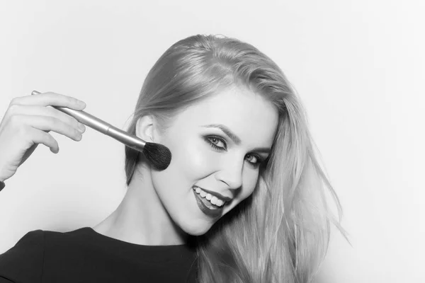 Šťastná žena použití make-up na obličej s štětec na pudr — Stock fotografie