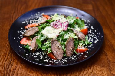 Yeşil yaprakları ve peynirli salata tabağına et. Sağlıklı stil çanak hizmet. Sebzelerini ye, daha az sıkıştırma var