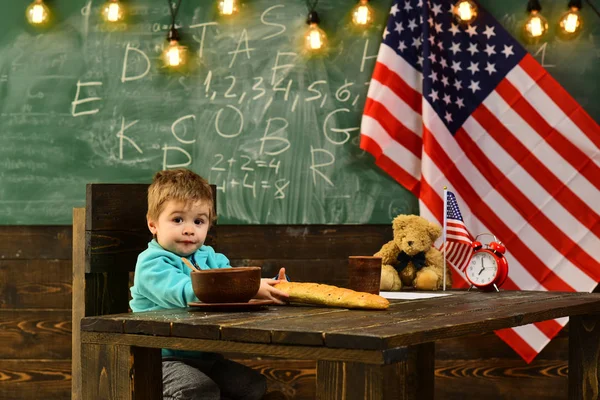 De vuelta a la escuela o a la escuela en casa. concepto de regreso a la escuela con niño pequeño en la bandera de EE.UU. en el día de la independencia . —  Fotos de Stock