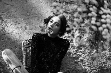 Güzel kadın ağzında beyaz çiçek ile poz