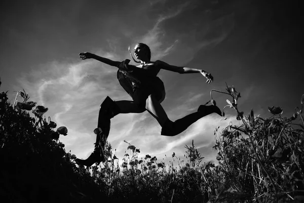 Zomer meisje springen in bloem gebied van maanzaad — Stockfoto