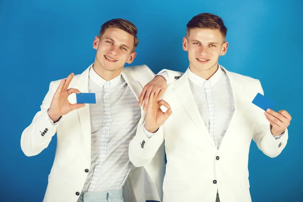 Geschäftsleute lächeln in weißen Jacken auf blauem Hintergrund — Stockfoto