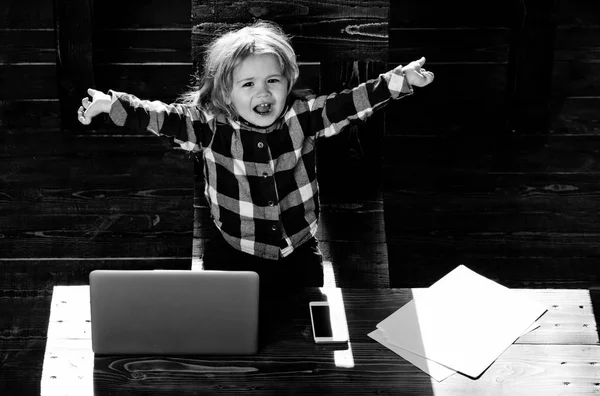 Menino feliz no escritório com laptop, telefone, folha de papel — Fotografia de Stock