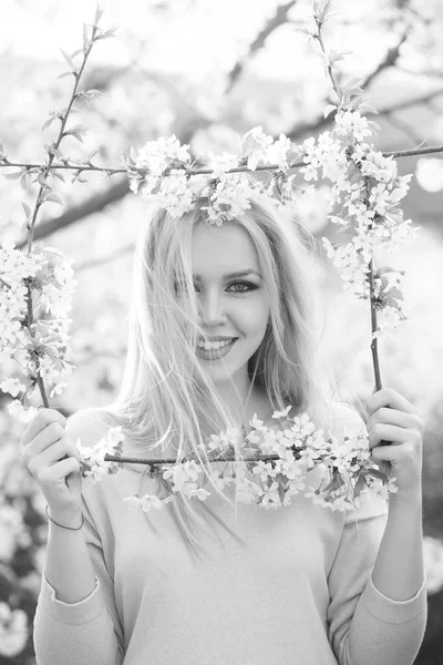 Fille heureuse souriant dans le cadre de blanc, fleurs florissantes — Photo