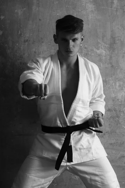 Man training karate in white kimono on beige background, sport — Stock Photo, Image