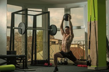 Spor ve spor salonu konsept. Sporcu, atlet, kas maço mu egzersiz trx döngüler ve sağlık topu, pencere arka plan ile. Adam çıplak gövde içinde jimnastik salonu ile eğitim, trx zevk.
