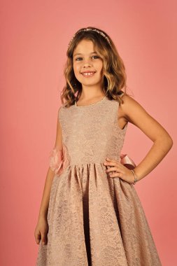 Bak, Kuaför, makyaj. Elegance şık seksi elbiseli kız çocuk. Şık elbiseli küçük kız balo. Moda ve güzellik, küçük prenses. Pembe bir arka plan, güzellik moda modeli.