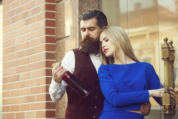 Закохана пара дивиться на пляшку вина — стокове фото