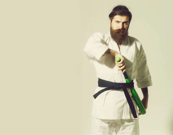 Bearded serious karate man in kimono with green baseball bat — Stock Photo, Image