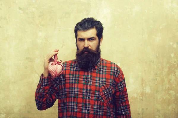 Homem barbudo feliz com barba detém coração têxtil rosado — Fotografia de Stock