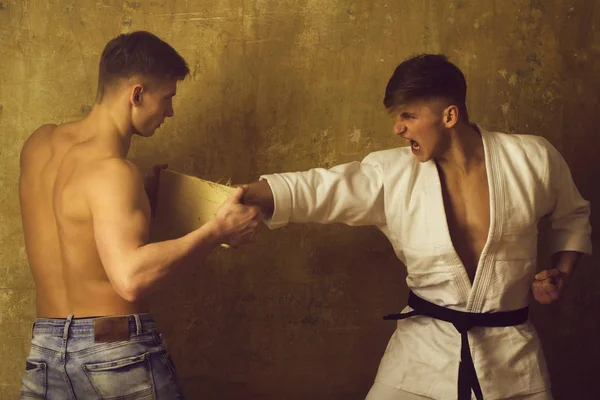 Sparringsport, Karate-Trainingskampf, zwei Kämpfer auf beigem Hintergrund — Stockfoto