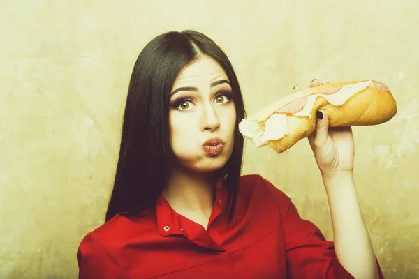 Sexy pretty brunette surprised woman eats big sandwich or burger — Stock Photo, Image