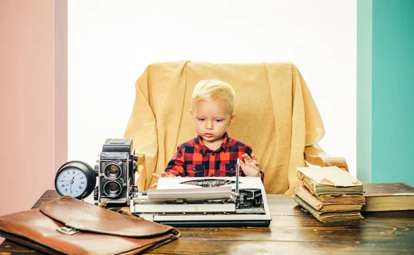 Kleine schrijver werken op boek bij receptie. Jongen schrijver type op vintage typemachine in kantoor — Stockfoto