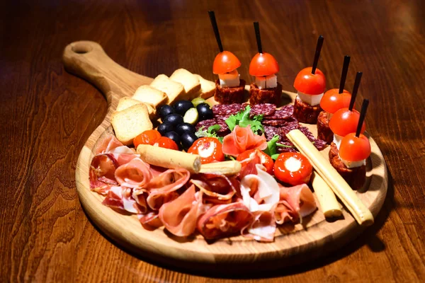 Plateau de viande avec canape sur table en bois. Viandes froides au restaurant. Arrêtez, mangez et partez. — Photo