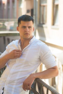 Balkon mali şehir merkezinde Rails eğilerek yakışıklı ve güçlü bir adam