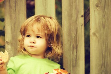 küçük çocuk ahşap çit yakınındaki pasta yemek