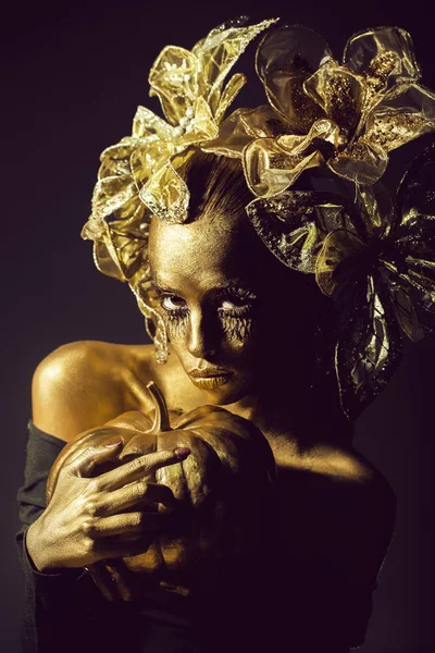 Golden woman with halloween pumpkin — Stock Photo, Image