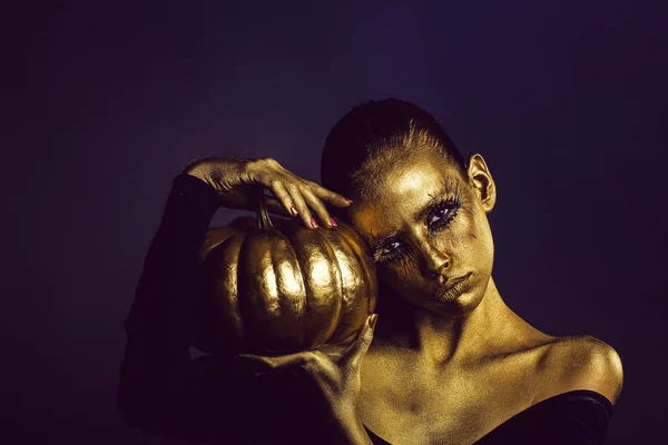Goldene Frau mit Halloween-Kürbis — Stockfoto