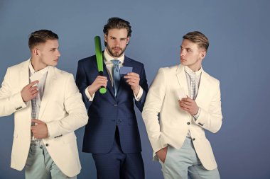 Beyzbol sopası mavi arka plan üzerinde tutan adam