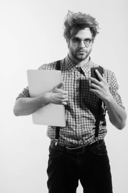 Smartphone ve dizüstü bilgisayar nerd bardaklarda yakışıklı adam