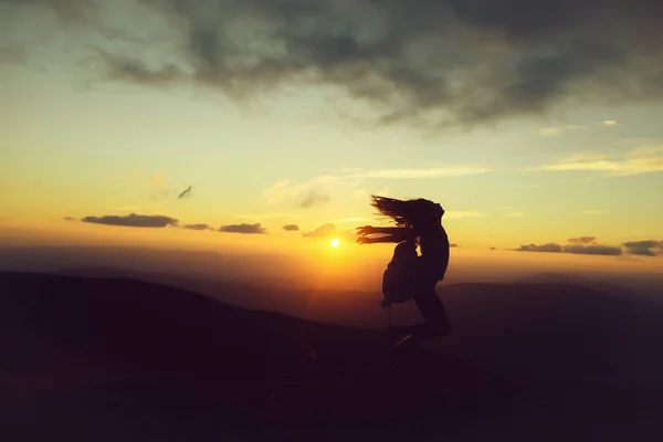 Mujer al atardecer o al amanecer en las montañas — Foto de Stock