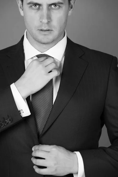 Boss adjusting tie in elegant navy formal suit — Stock Photo, Image