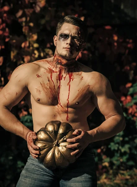 Halloween guy with gold traditional pumpkin.