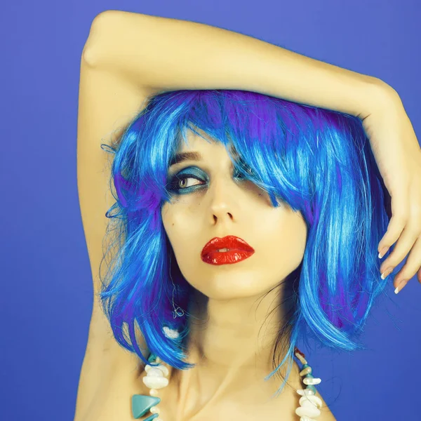 Woman in blue wig with fashionable makeup.