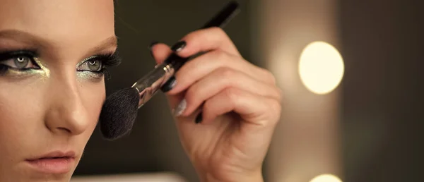 Mujer aplicando base tonal cosmética seca en la cara usando cepillo de maquillaje . — Foto de Stock