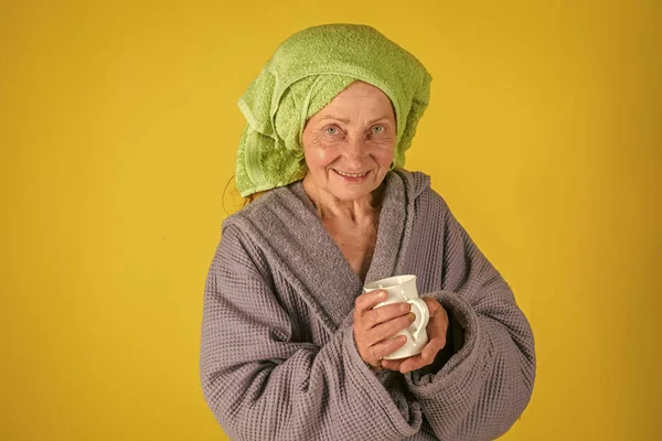 Velha senhora em turbante toalha com copo . — Fotografia de Stock