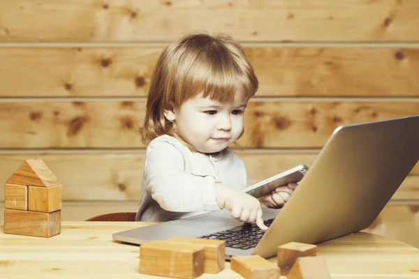 Маленький мальчик с компьютером и телефоном — стоковое фото