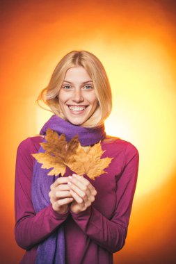 Sonbahar Yılın güzel ve renkli bir zamanı. Mutlu sonbahar kadın gülümsüyor. Güzellik yüz. Sonbahar yaprakları Festivali. Senin metin için yer. Model yüz. Altın arka plan.