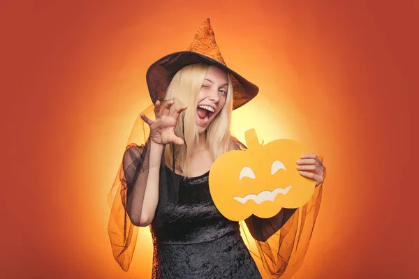 Chica jugar con calabazas y reat. Feliz fin de semana de Halloween. Sombrero de bruja. Feliz Halloween con calabazas en un fondo de Halloween. Horrorbackground. Caras de horror. Fiesta de Halloween . — Foto de Stock