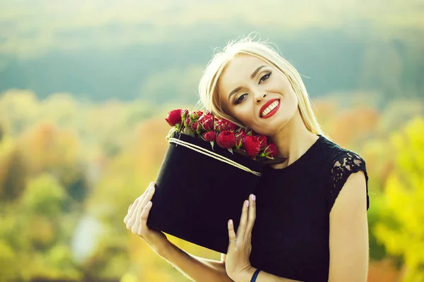 Hezká dívka s květinami v poli — Stock fotografie