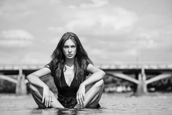 Ung sexig kvinna sitter i vatten — Stockfoto
