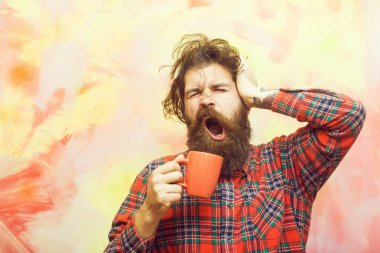 sakallı adam holding saçak saç ve turuncu Kupası esneme