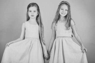 Mutlu çocuk içeride eğleniyor. Yazlık elbise içinde oynayan çocuklar. Pembe bir arka plan üzerinde küçük kızlar