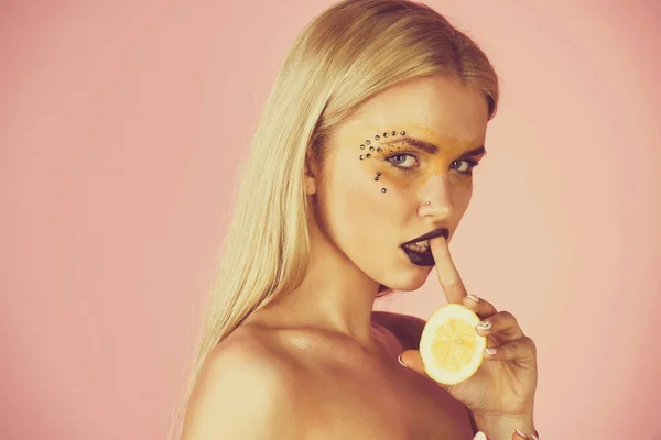 Junges Mädchen hält gelbe Zitrone auf rosa Hintergrund — Stockfoto