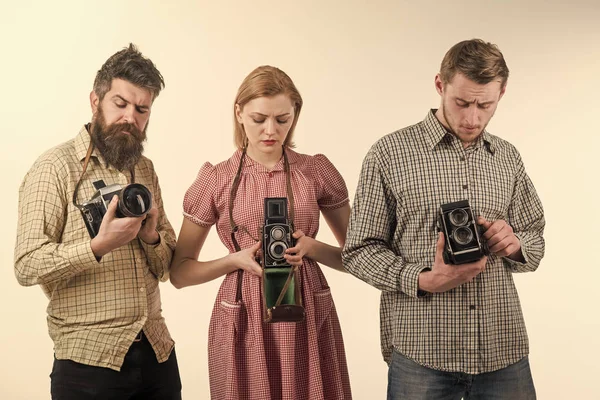 Company of busy photographers with old cameras, filming, working. Vintage fashion concept. Men and woman on pensive faces on white background. Men in checkered clothes, retro style. — Stock Photo, Image