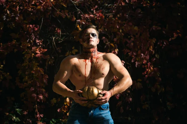Halloween muž s tváří zombie na podzimní listí pozadí. — Stock fotografie