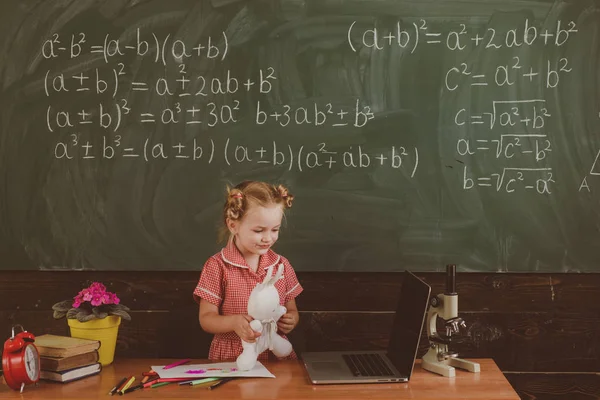 Concetto di computer. Ragazza giocare con il computer portatile in classe scuola. Filtro wireless semplice, vintage — Foto Stock