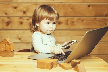 Bilgisayar ve telefon ile küçük çocuk