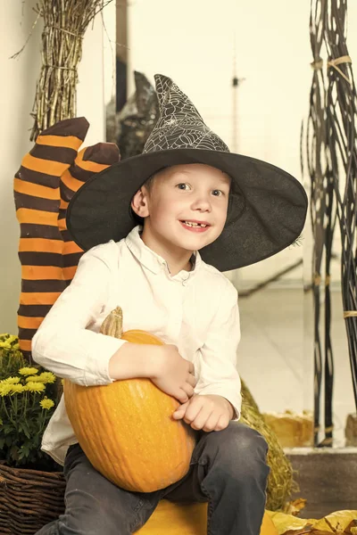 Halloween niño con calabaza naranja en sombrero de bruja . —  Fotos de Stock