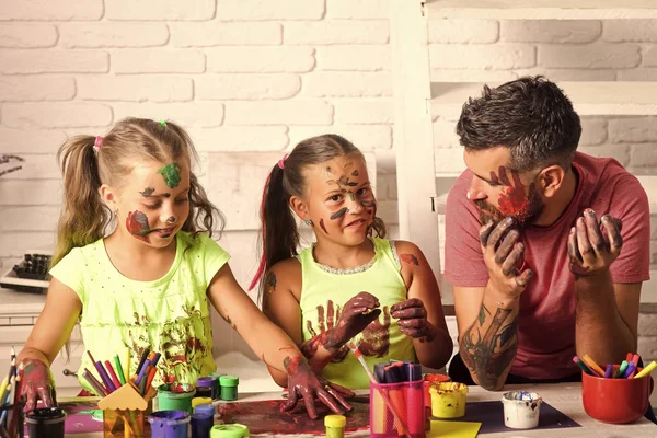 Dad and daughters drawing with colorful paints