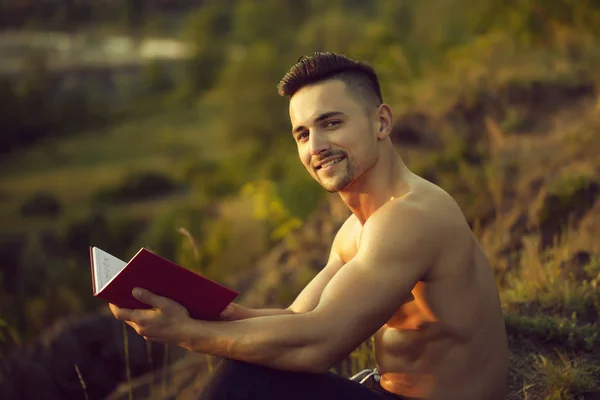 Uśmiechnięty mężczyzna mięśni z książki odkryty — Zdjęcie stockowe